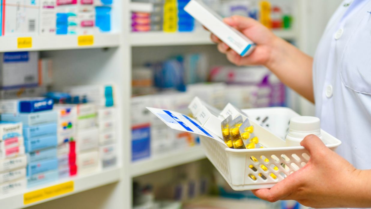 A friendly pharmacist assisting a customer at a Japanese pharmacy counter.