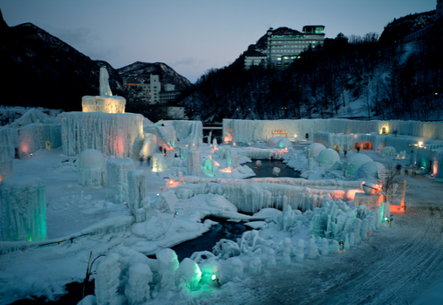 Night view of an illuminated ice festival with ice sculptures and structures in Hokkaido, Japan.
