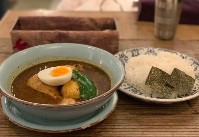 A bowl of Hokkaido-style soup curry served with rice on the side.