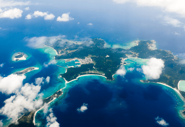 Aerial view of the Kerama Islands in Okinawa, featuring vibrant blue ocean and small islands scattered across the water.