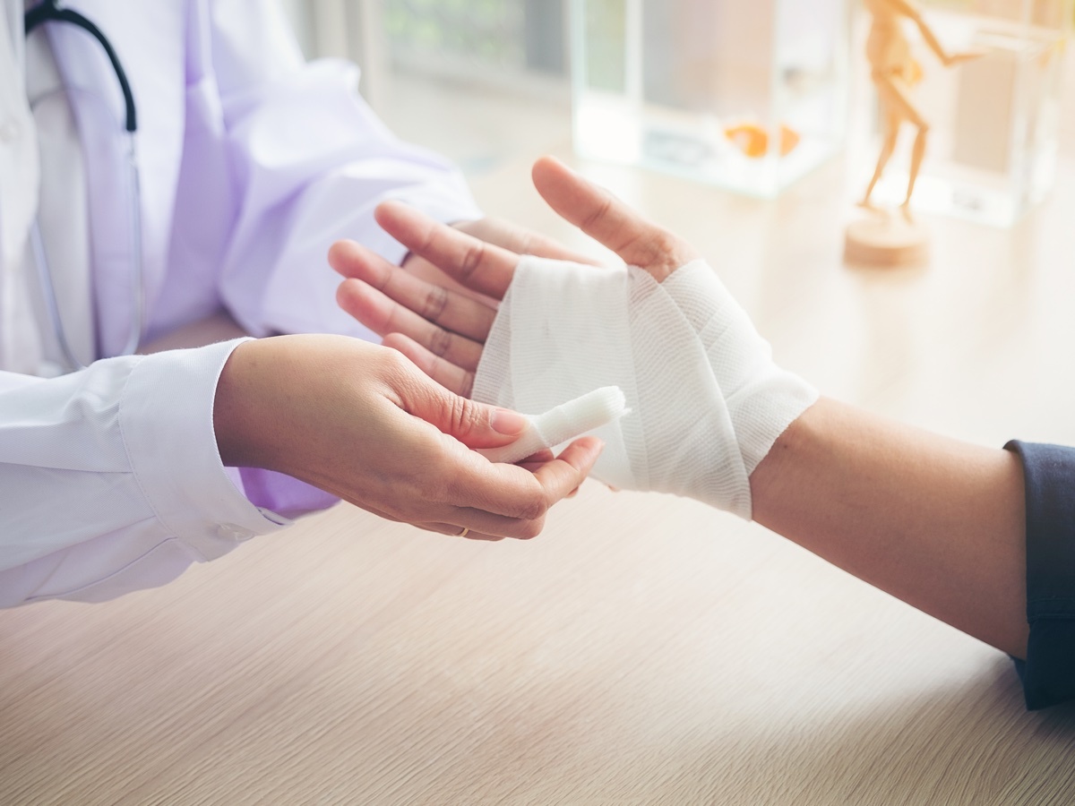 a japanese doctor wrapping bandages around a patients hand in a japanese hospital