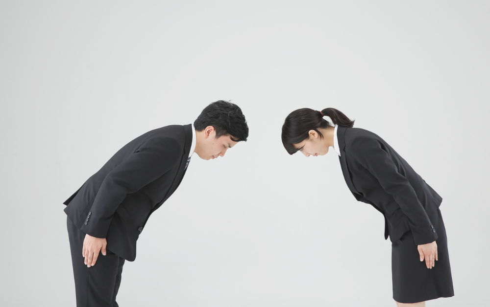 Two Japanese people bowing, work culture