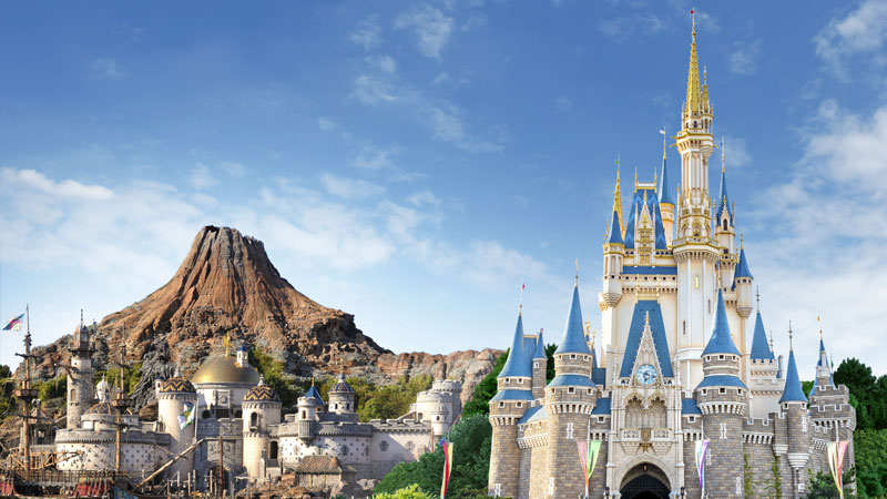Blog post image of tokyo disney land and tokyo disney sea japan displaying the iconic disney castle and the disney sea valcano